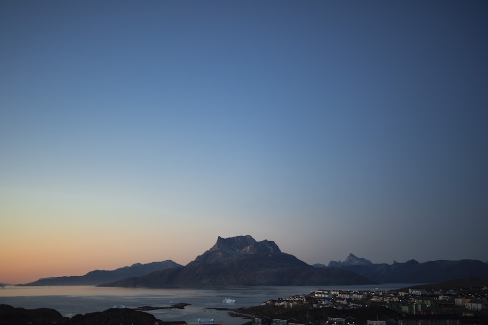 a view of a mountain with a body of water in the foreground