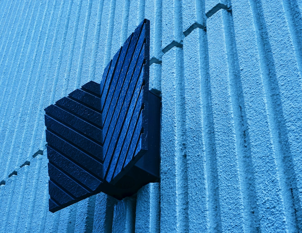 black metal frame on blue concrete wall