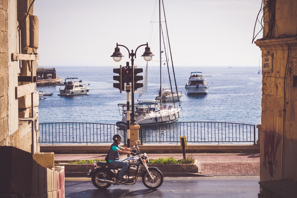 black and red motorcycle parked on brown wooden dock during daytime