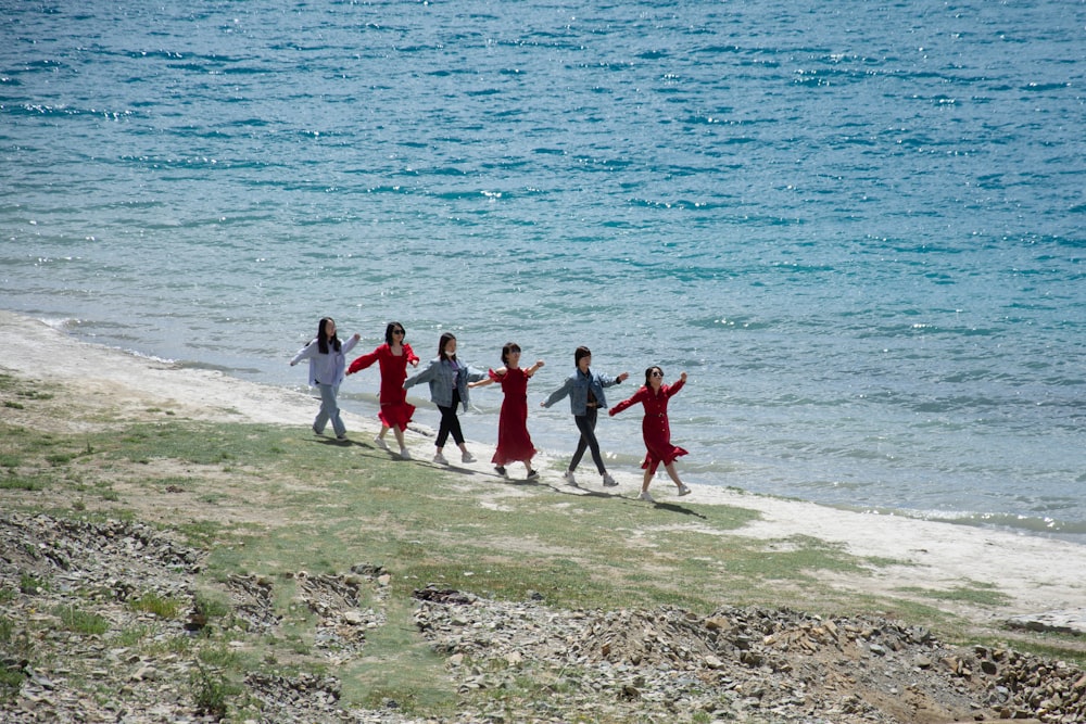 group of people standing on white sand beach during daytime