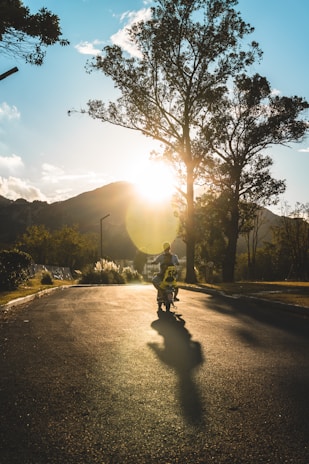 Action shot of a rider zooming down a dirt trail on a rugged mini motorbike at sunset.