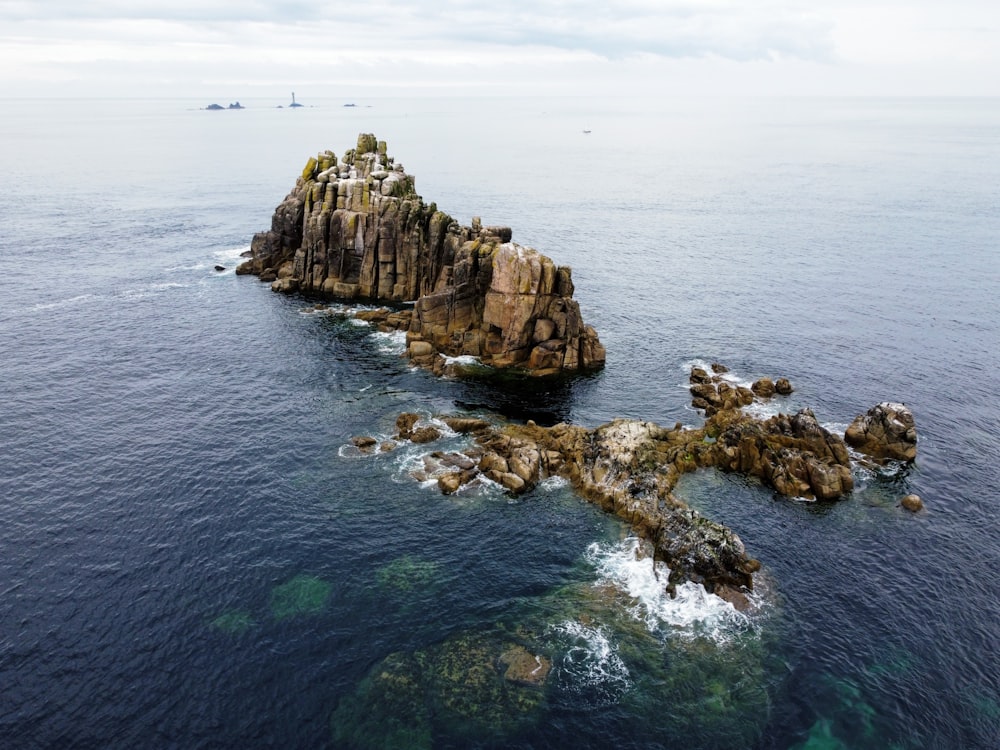 brown rock formation on body of water during daytime