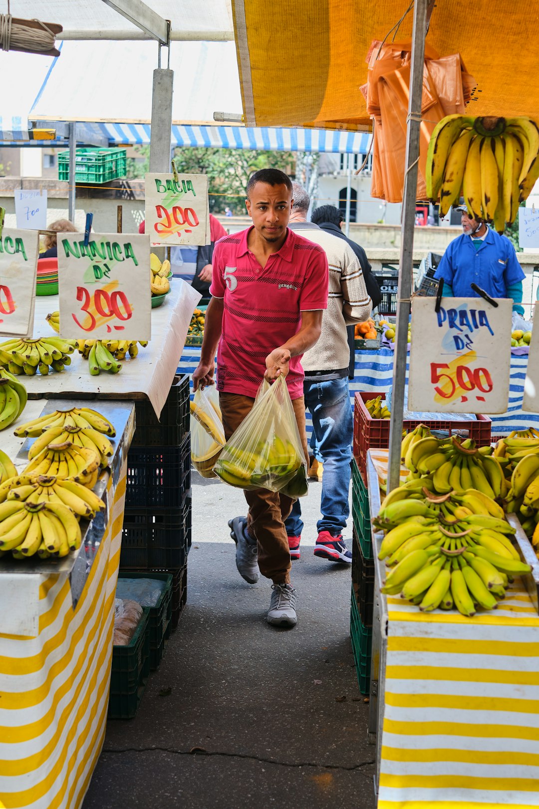 woman in red crew neck t-shirt holding yellow banana