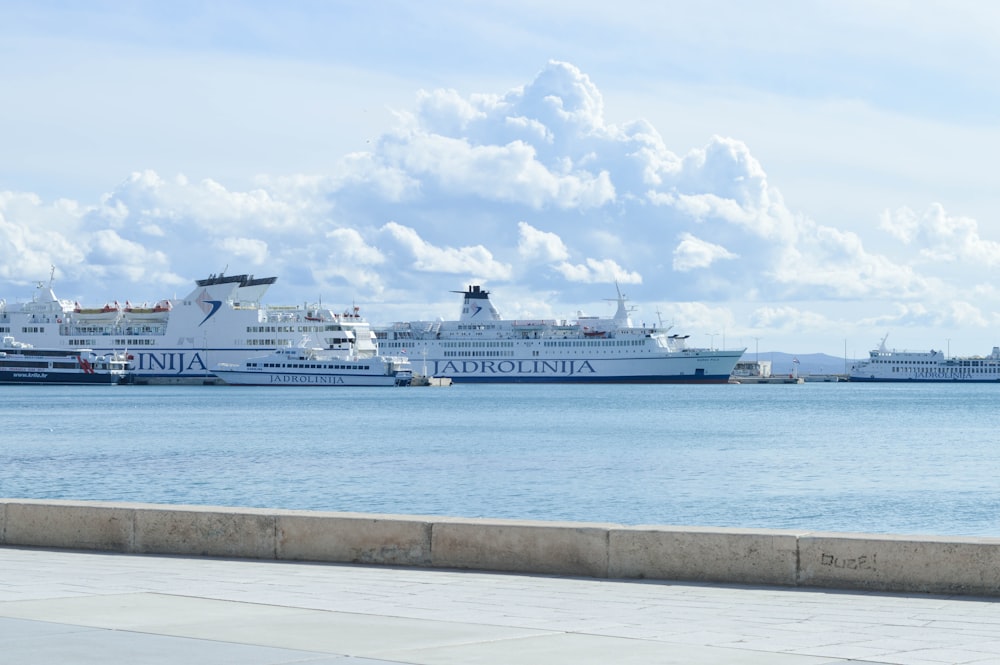navio de cruzeiro branco no mar sob nuvens brancas e céu azul durante o dia
