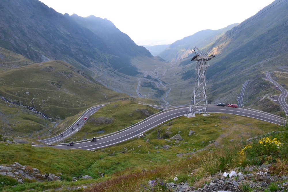 cars on road between green grass covered mountains during daytime