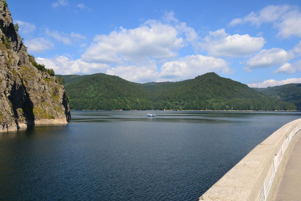 body of water near mountain under blue sky during daytime