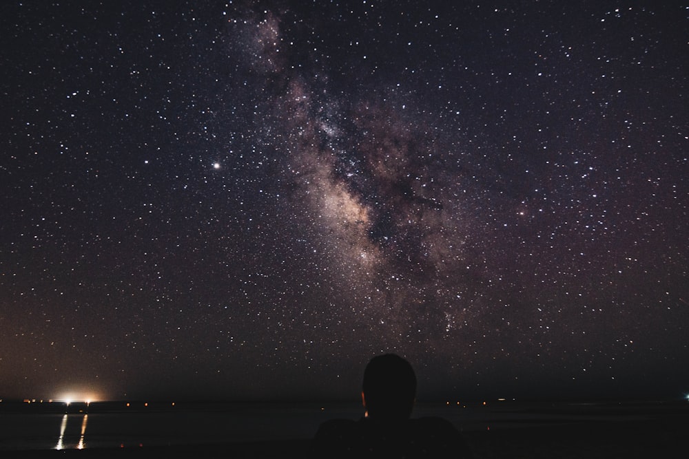 silhouette of man and woman under starry night