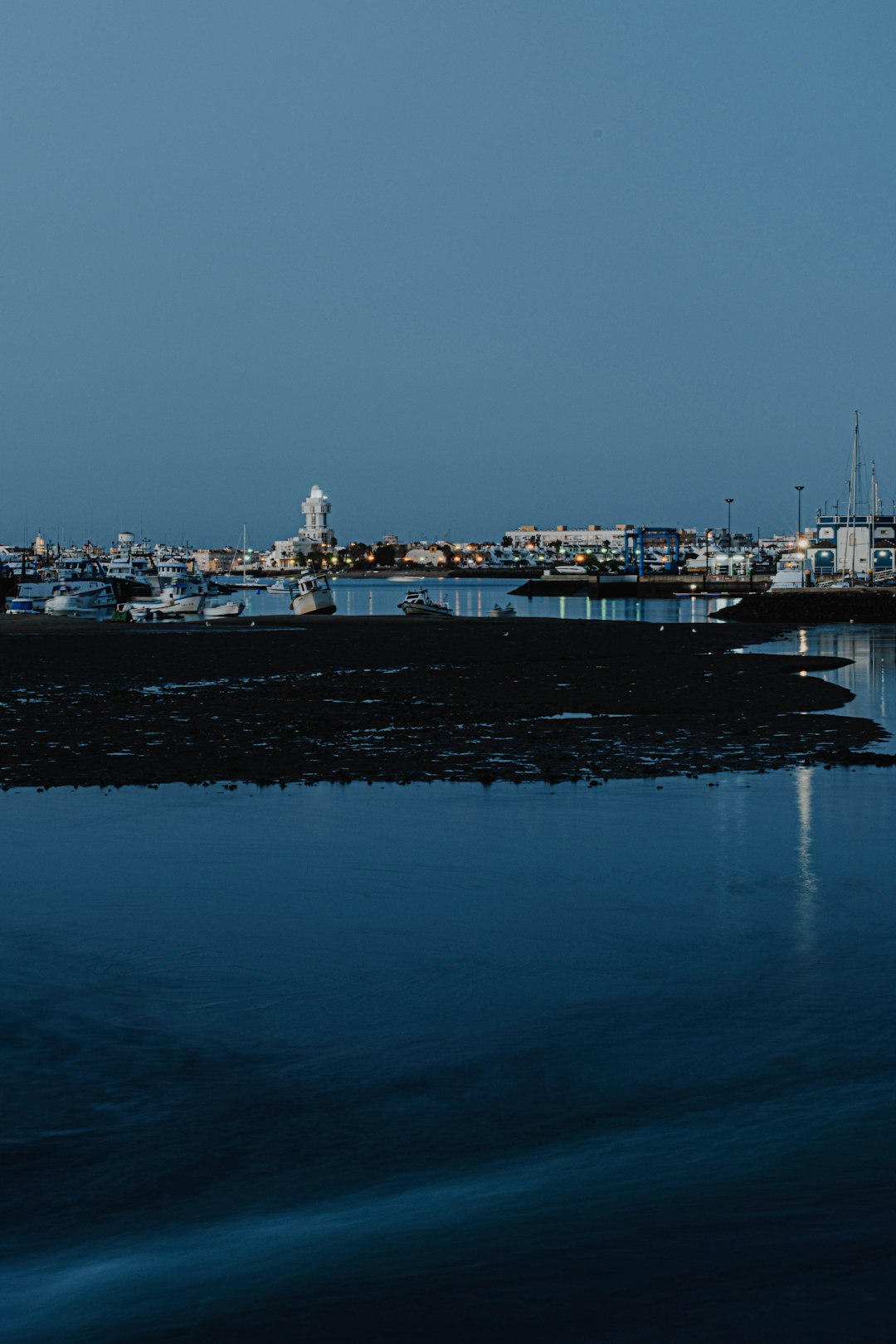 city skyline across body of water during night time