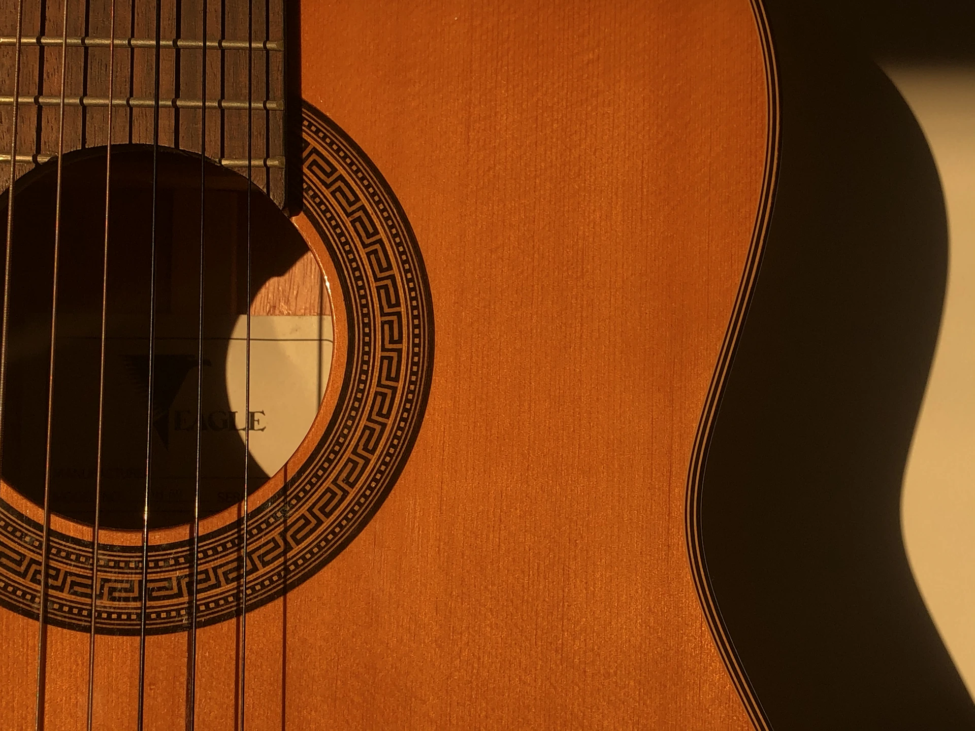 brown acoustic guitar on white textile