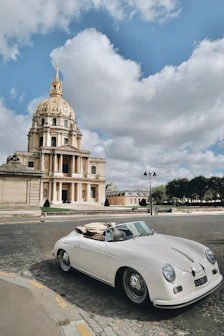 Voiture de luxe garée devant un immeuble parisien, illustrant l'art de vivre proposé par Luxora