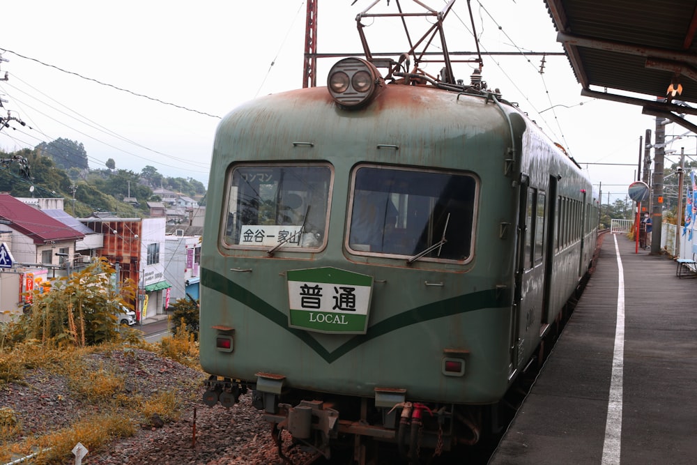 green train on rail during daytime