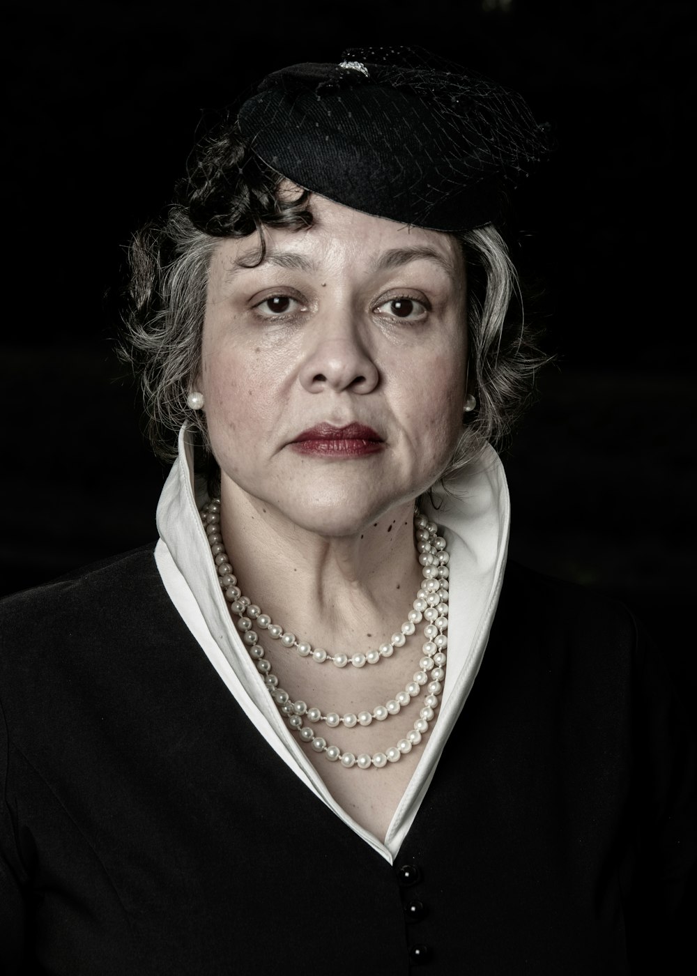 woman in black coat wearing white pearl necklace