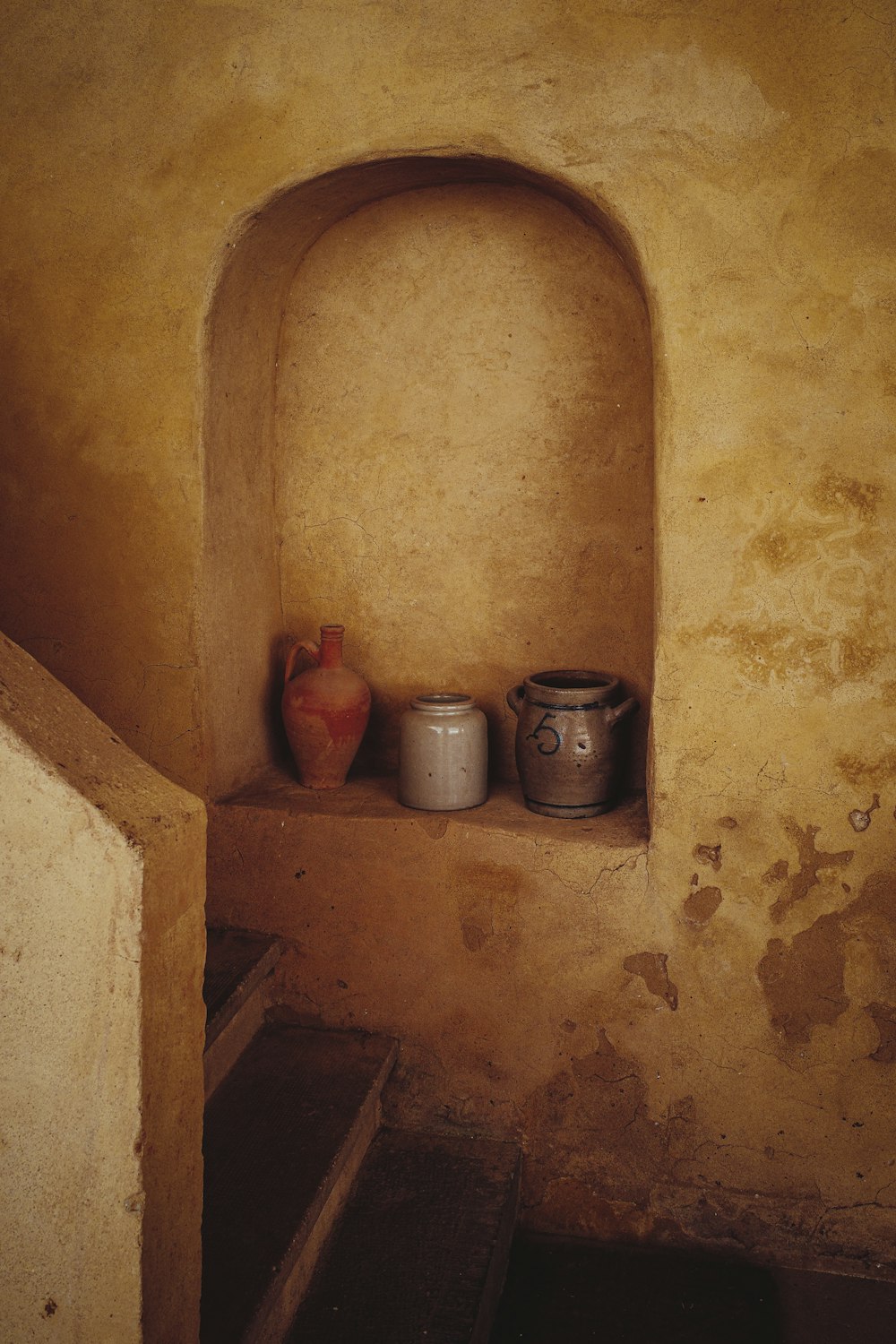 vasi di argilla marrone su muro di cemento marrone