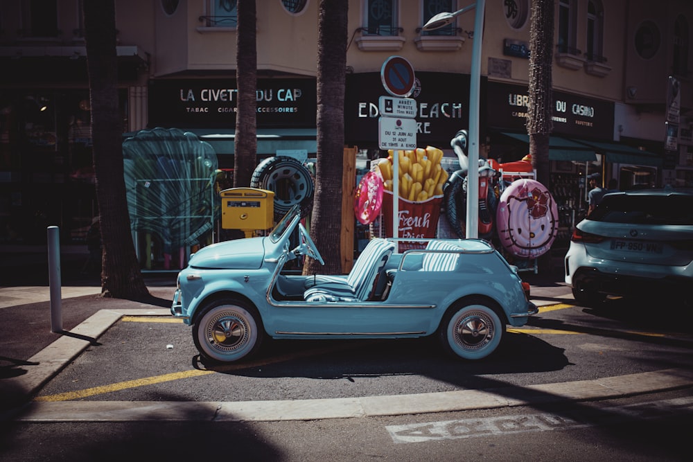 blue and white beetle car parked on sidewalk during daytime