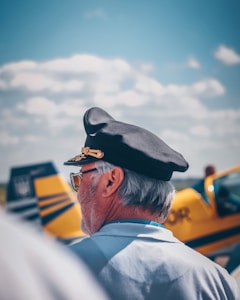 man in white collared shirt wearing black cap