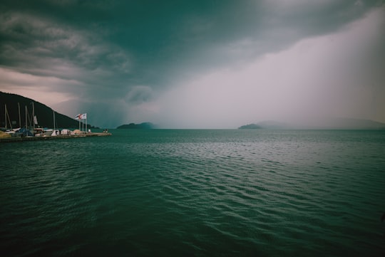 body of water under cloudy sky during daytime in Zugersee Switzerland