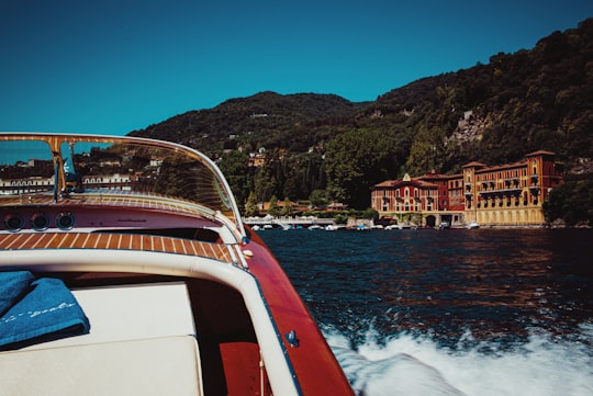 white and red boat on sea during daytime in Villa d'Este Italy