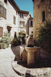 brown concrete fountain in front of brown concrete building during daytime