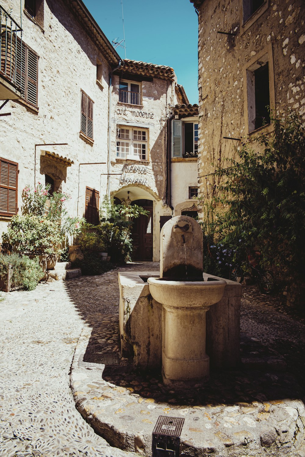 brown concrete fountain in front of brown concrete building during daytime