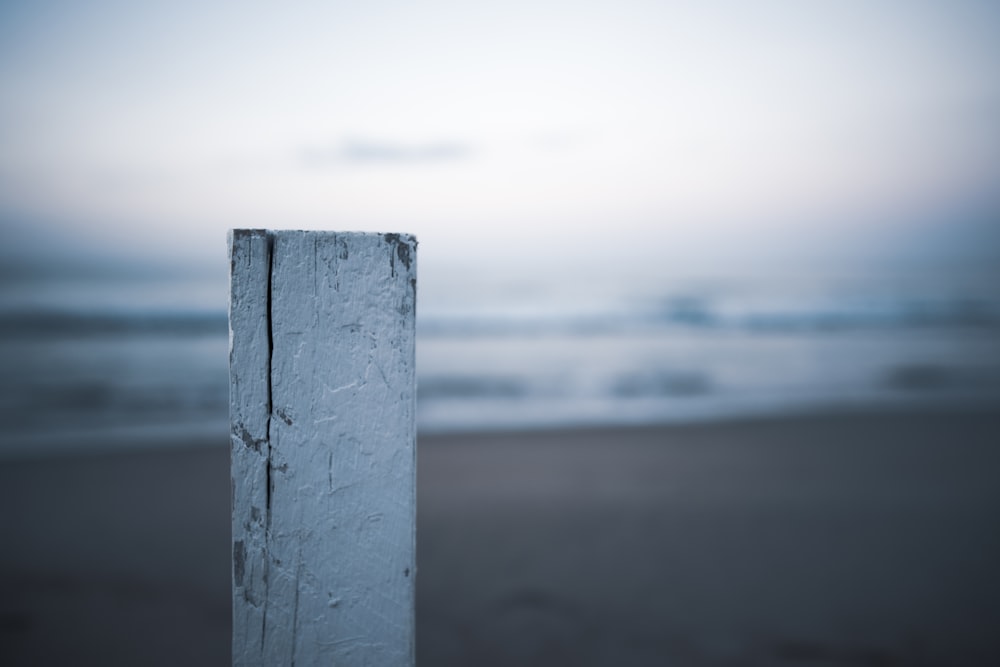poste de madeira branca perto do mar durante o dia