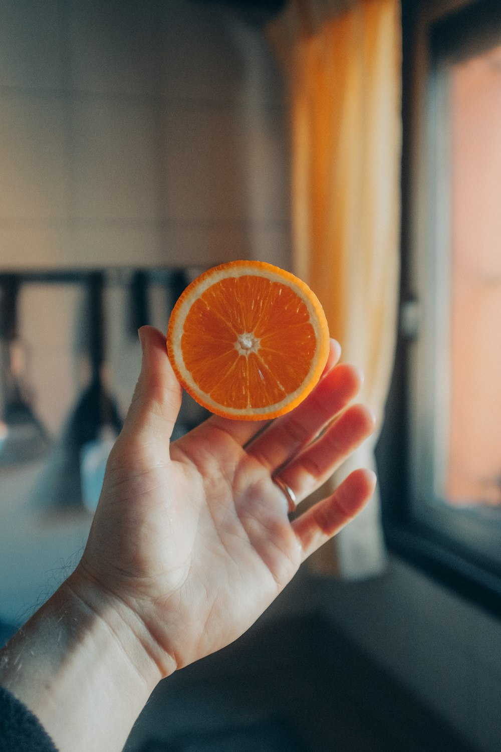 person holding sliced orange fruit