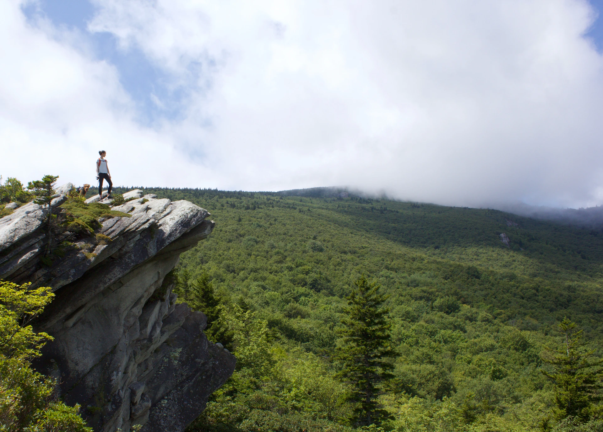 man in black shirt standing on rock formation during daytime