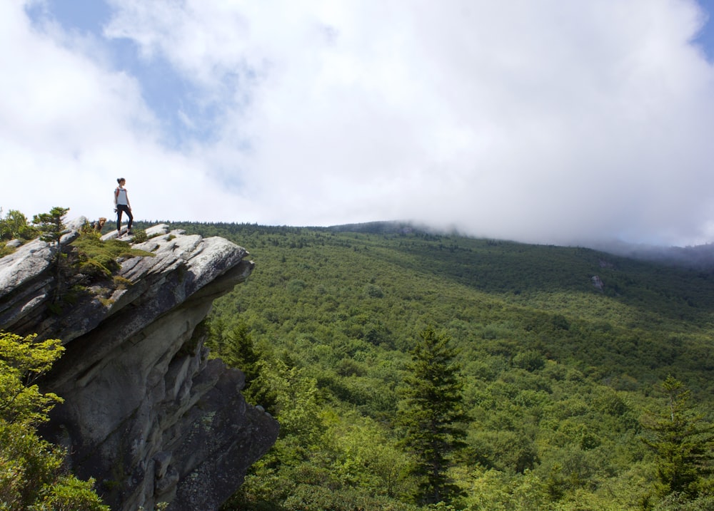 man in black shirt standing on rock formation during daytime