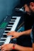 man in blue denim jacket playing piano