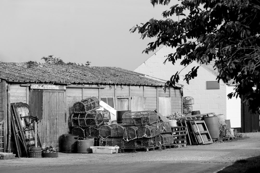 Graustufenfoto von Holzhaus in der Nähe von Bäumen