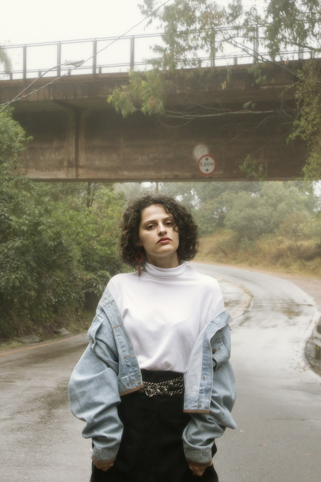 woman in white crew neck shirt and blue denim jacket standing on road during daytime