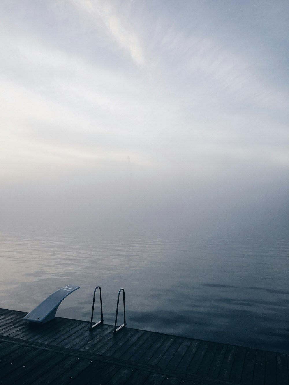 white boat on sea under white sky during daytime