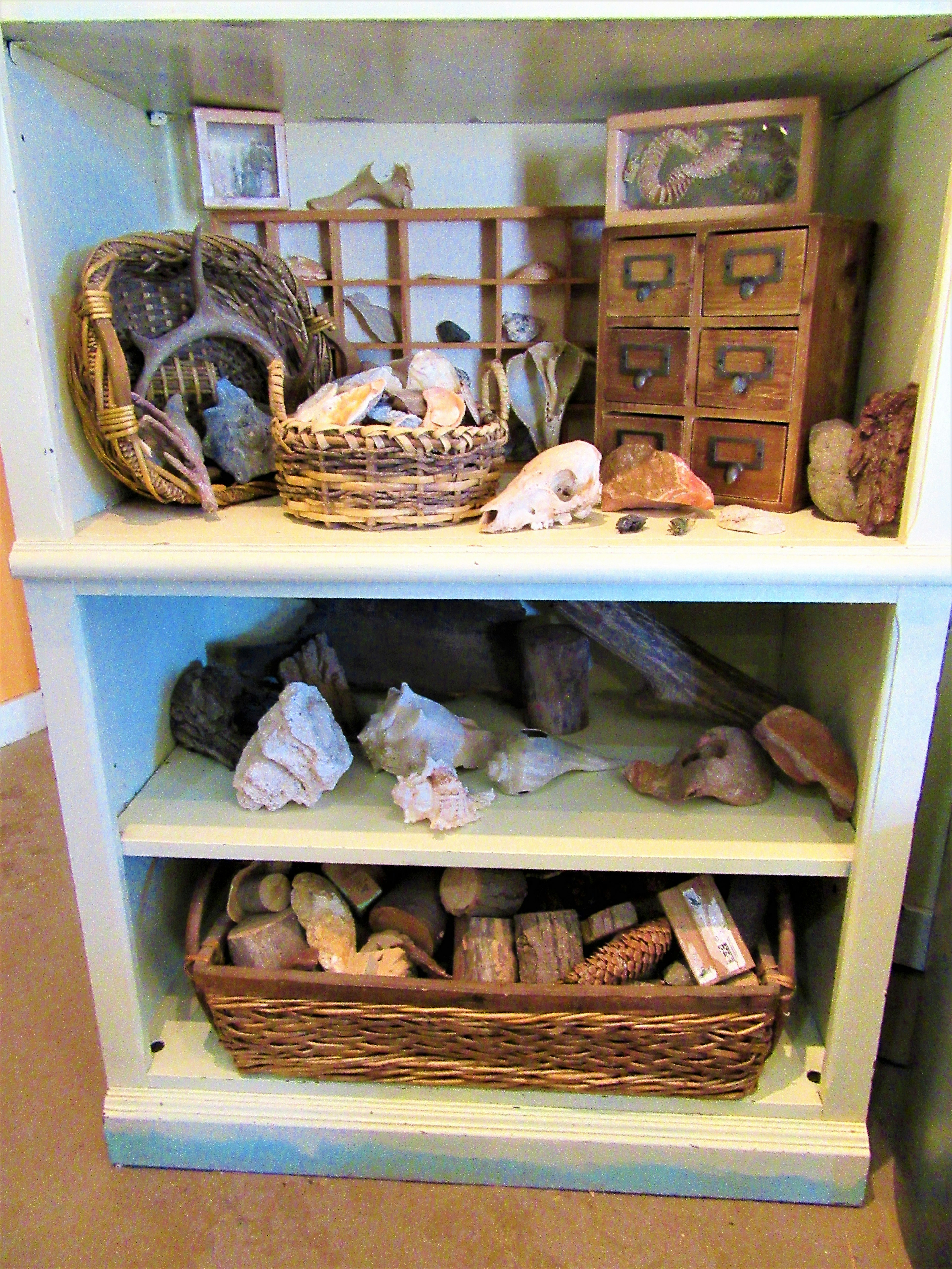 Solid wood display stand in natural finish holding decorative objects in a modern home