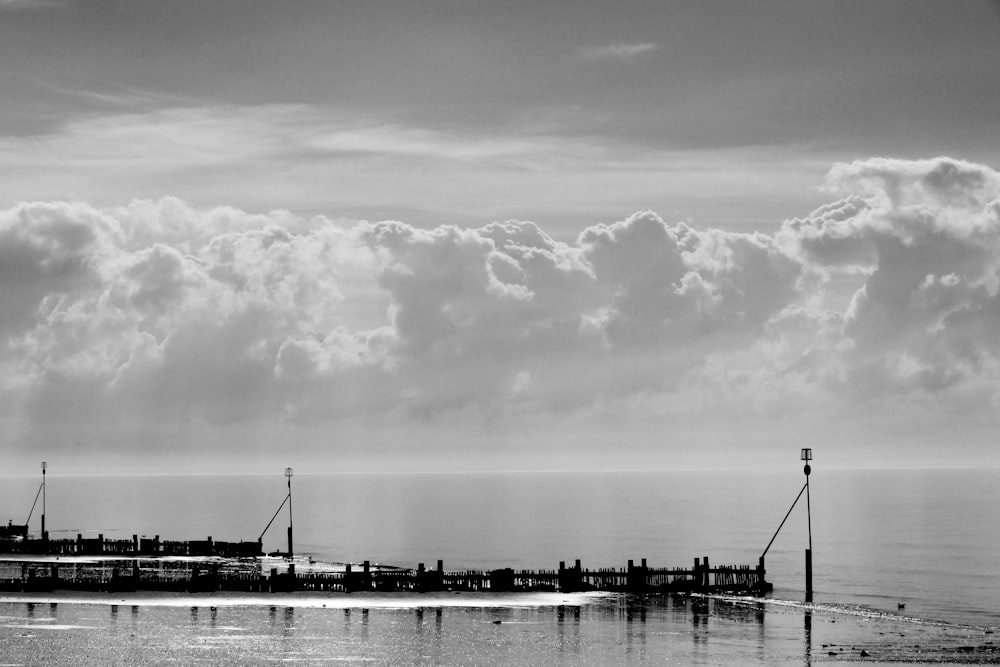 grayscale photo of body of water near city buildings under cloudy sky