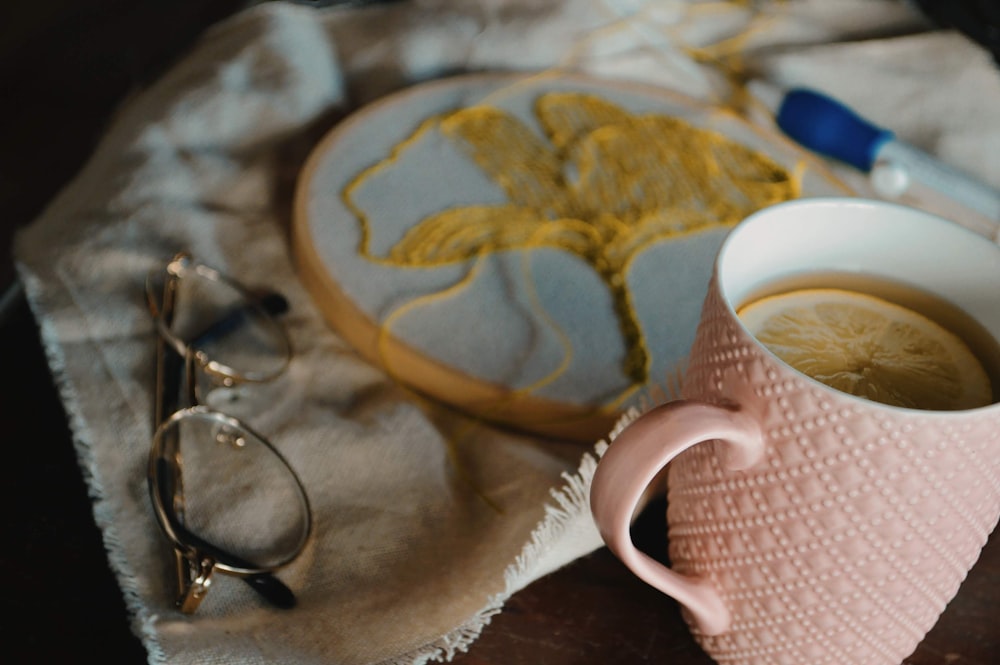 person holding white ceramic mug with brown liquid