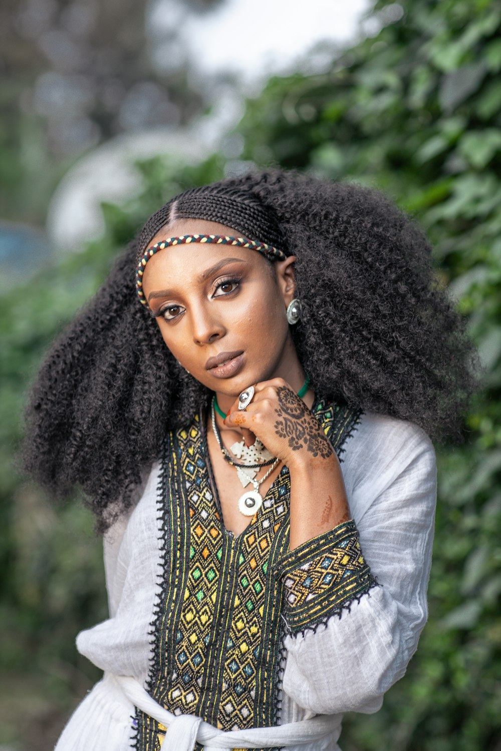 woman in white long sleeve shirt with black and brown scarf