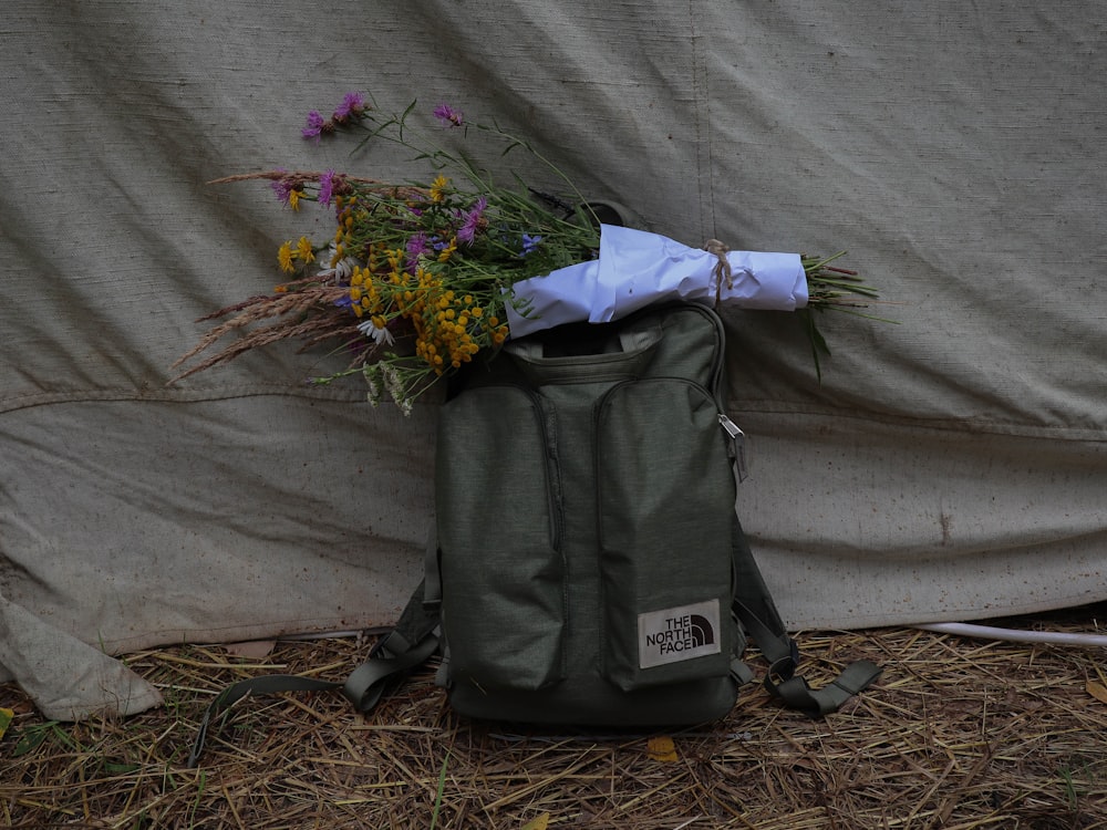 green and yellow flower bouquet on black and gray backpack