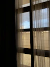 View of the room’s large window with sheer curtains.