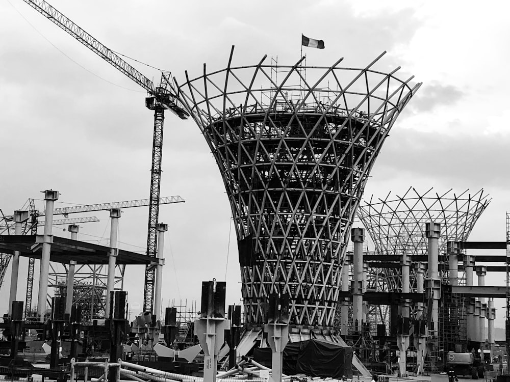 Foto en escala de grises de personas caminando por la calle cerca de los edificios y el puente de la torre