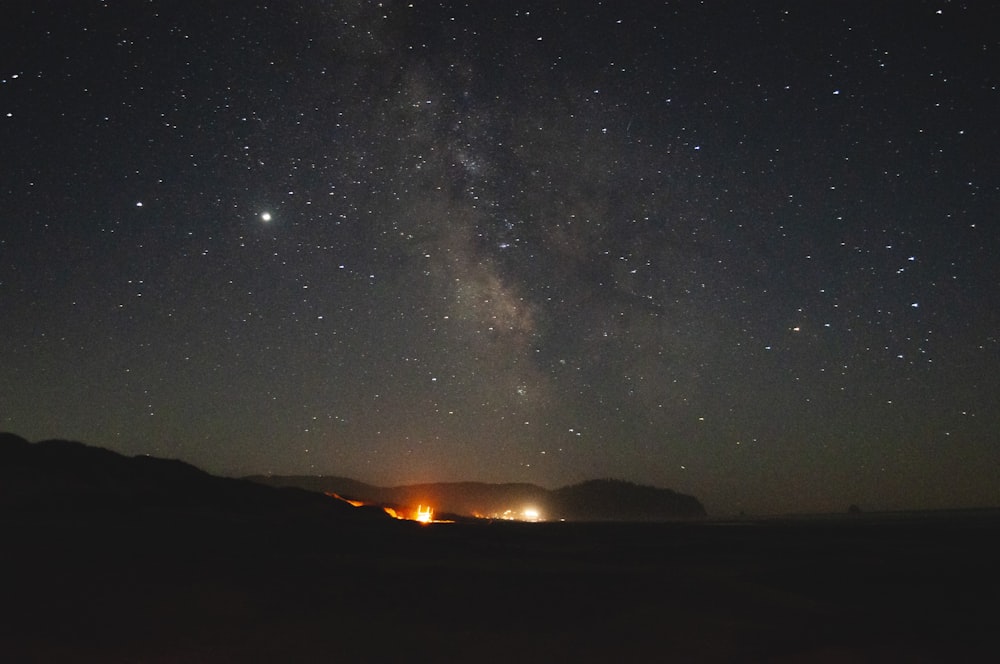 silhouette of mountain under starry night