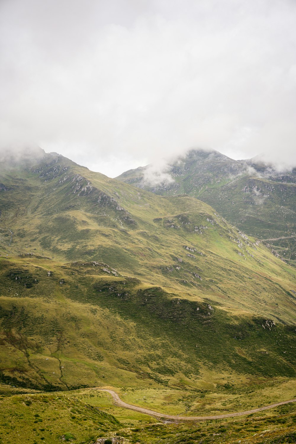 green and black mountain under white clouds during daytime