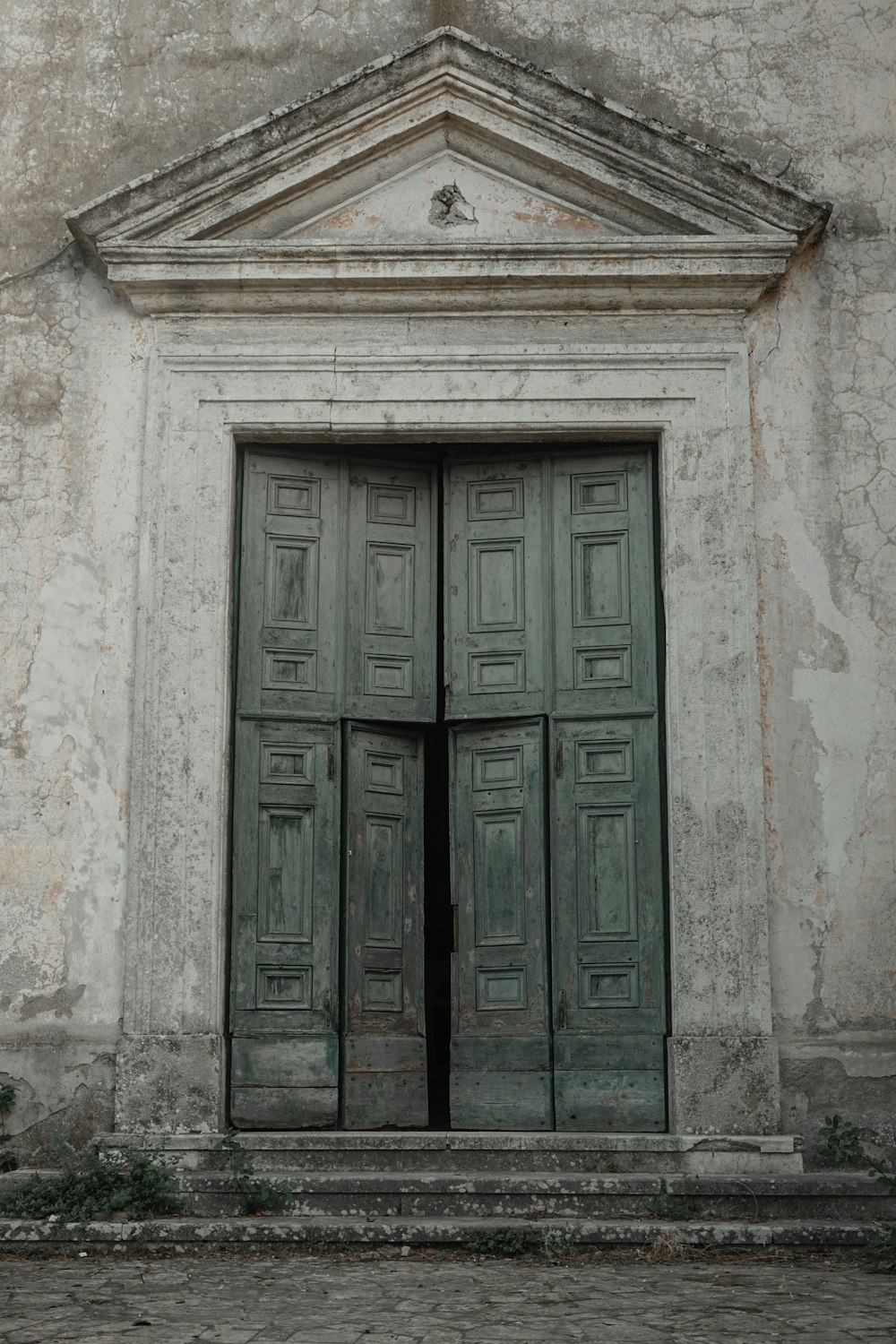 green wooden door on white concrete wall