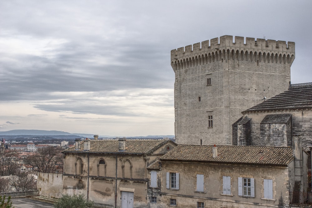 edificio in cemento marrone sotto il cielo nuvoloso durante il giorno