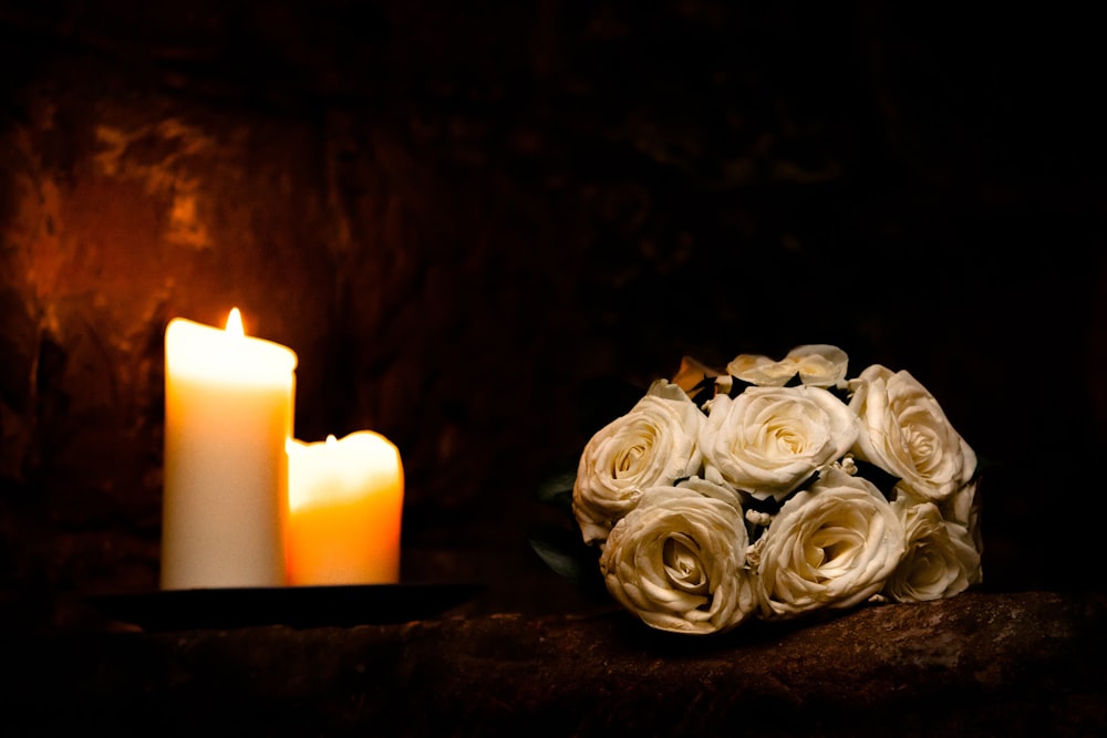 white rose flowers beside white candles