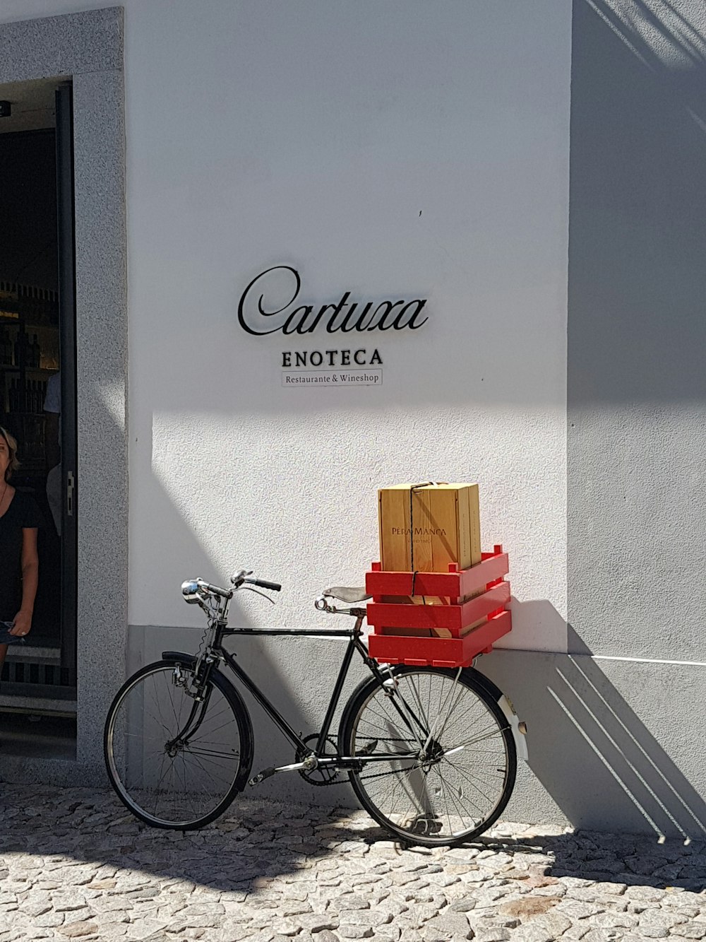 Bicicleta urbana negra con caja roja en la carretera