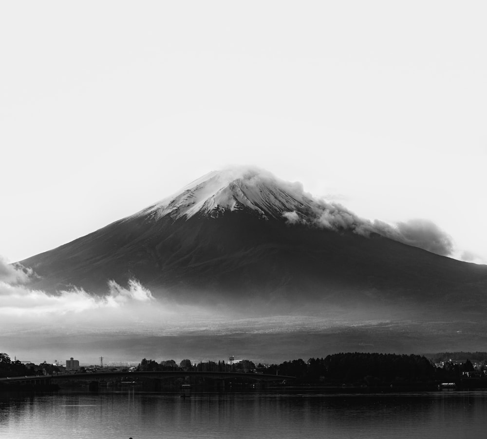 grayscale photo of mountain near body of water