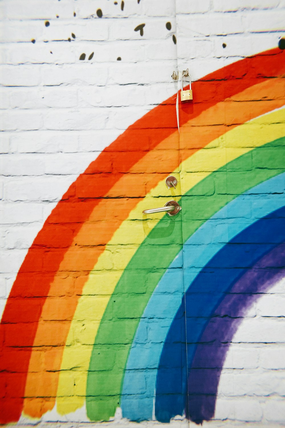 personne en chemise rouge et jean bleu debout sur le mur multicolore