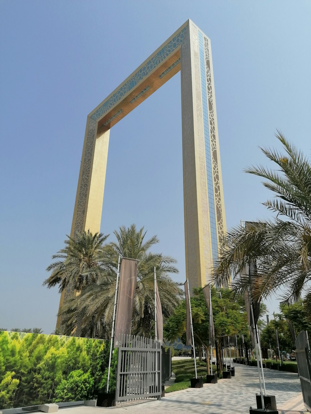 beige concrete building near palm trees under blue sky during daytime