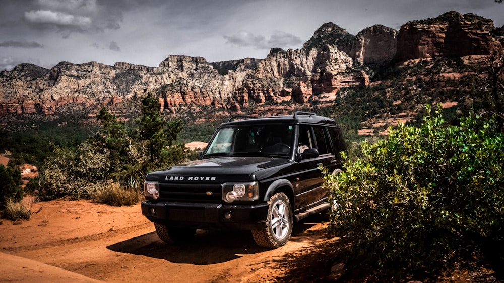 Mercedes Benz Classe G SUV noire sur un chemin de terre brun pendant la journée