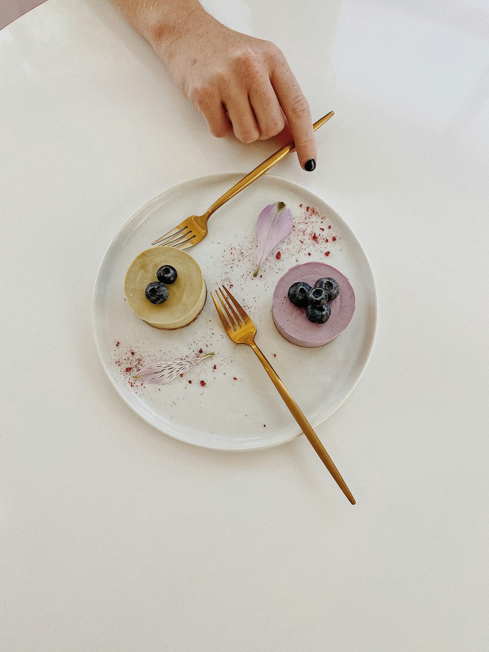 person holding fork on white ceramic plate