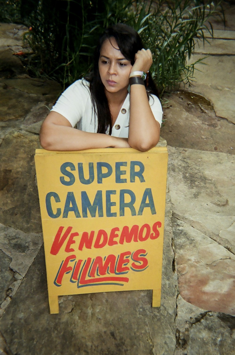 woman in white shirt holding yellow happy birthday signage